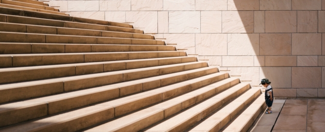 toddler's standing in front of beige concrete stair