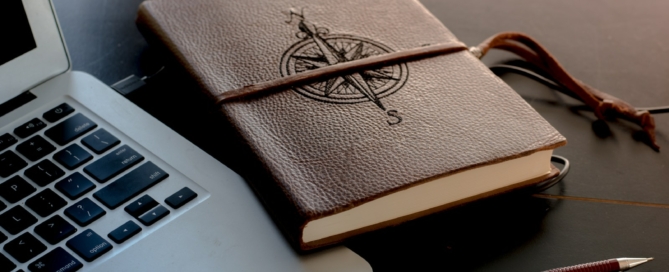 brown book beside MacBook